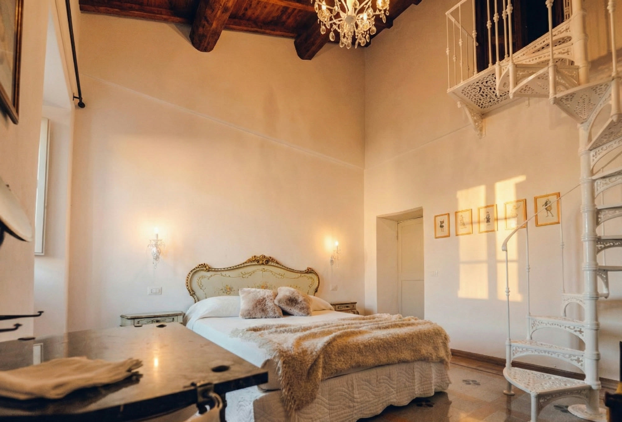 Double-height room with chandelier and white spiral staircase